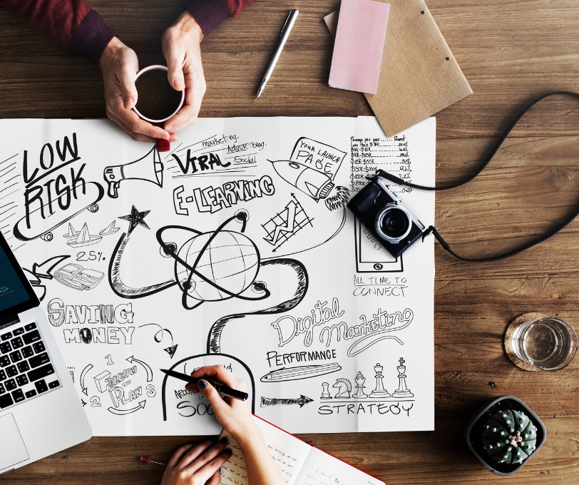 Mesa creativa con dibujos, lettering y herramientas de contenido